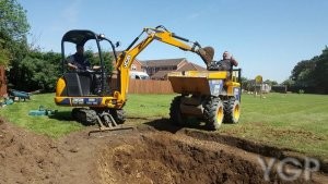 image of a digger next to pond being built